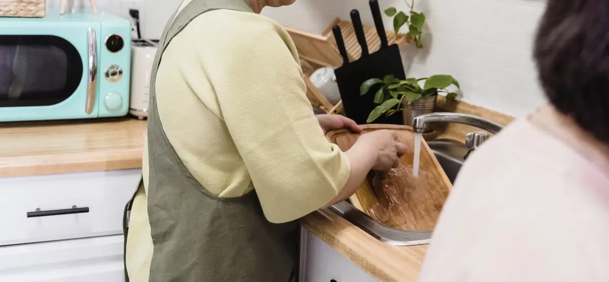 person cleaning a chopping board